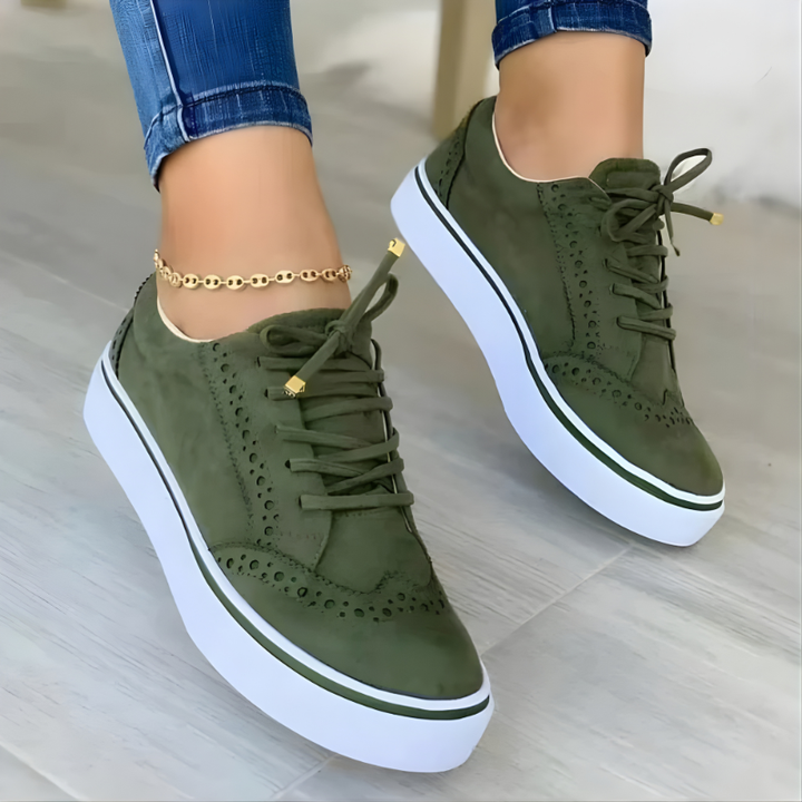 Green lace-up orthopedic sneakers with perforated panels and white platform sole.