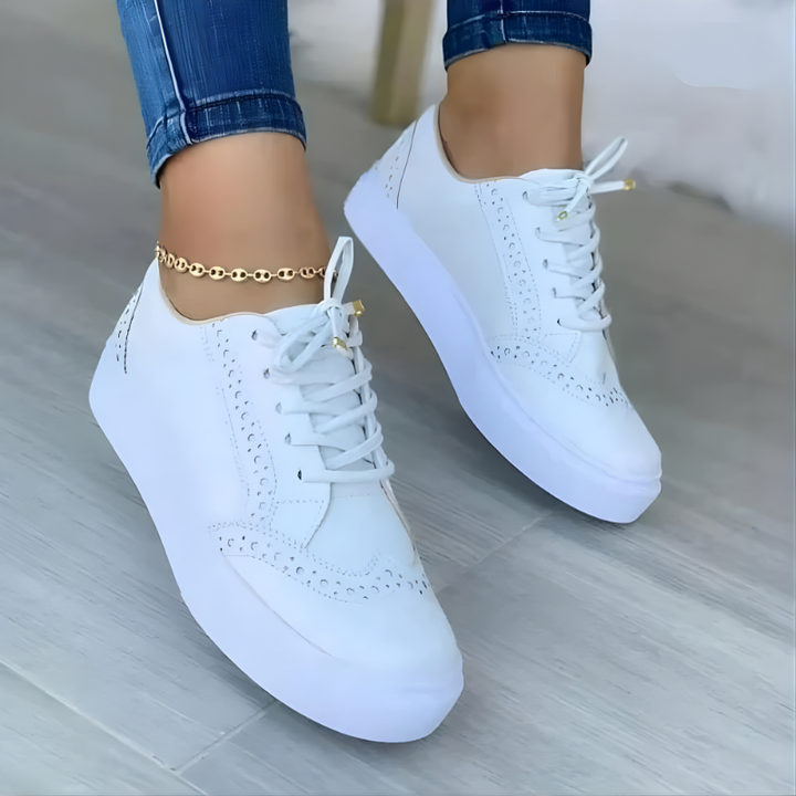 White lace-up orthopedic sneakers with perforated panels and white platform sole.