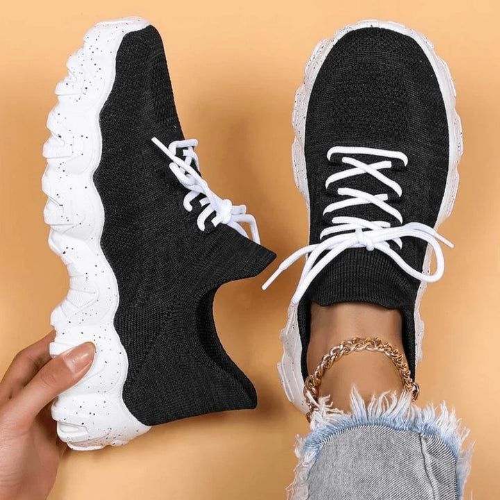 Black knit lace-up sneakers with white speckled sole, front view and heel