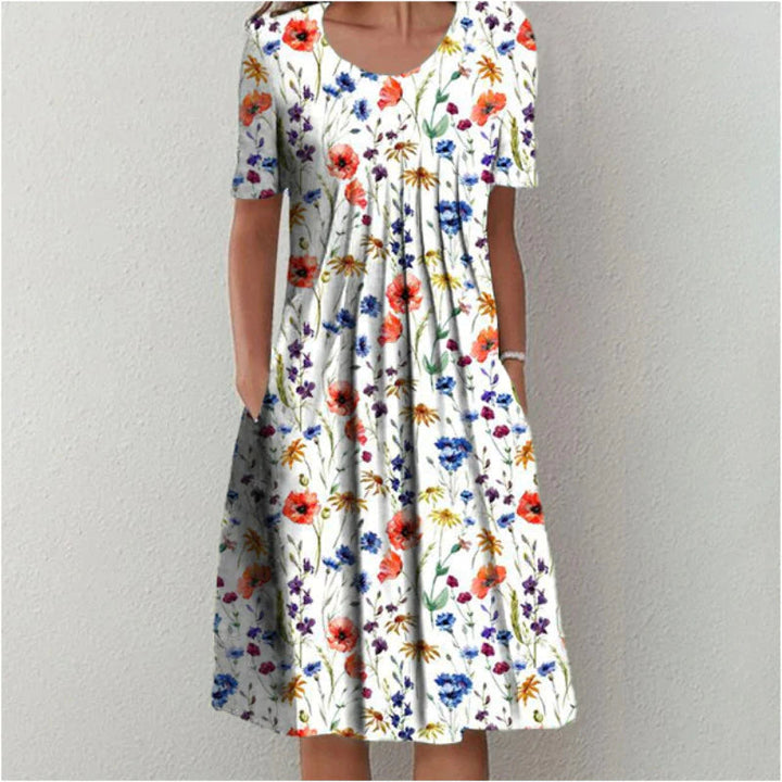 White floral tummy control dress with red, blue, and yellow flowers, short sleeves