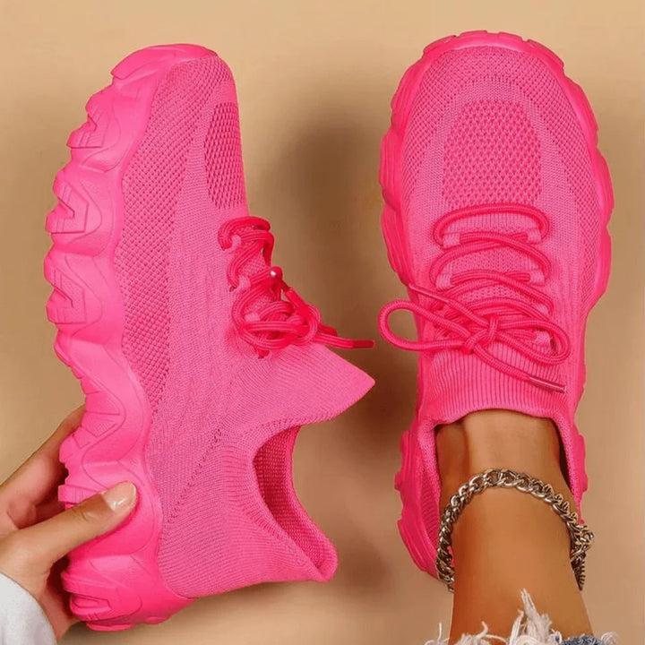 Pink knit lace-up sneakers with chunky tread sole, side view