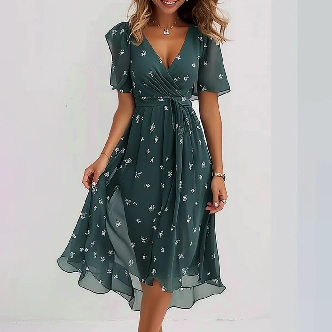 Elegant printed dress in dark green with small white floral pattern, fitted waist and midi skirt