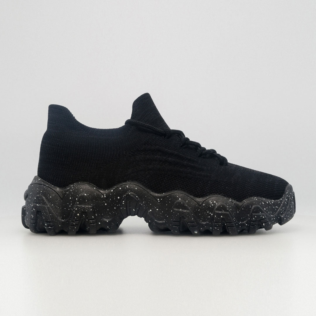 Black knit orthopedic sneaker with lace-up closure and speckled chunky tread sole