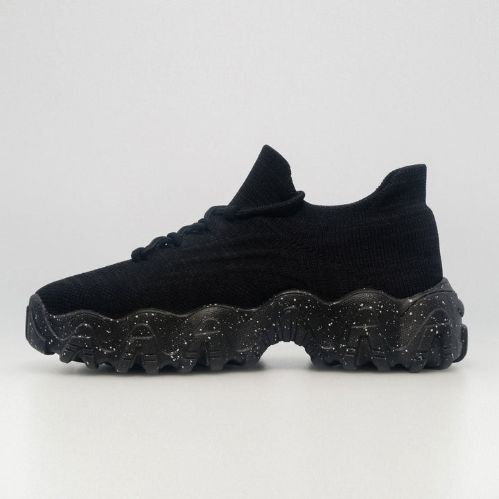 Black knit orthopedic sneaker side view with speckled outsole and lace-up closure