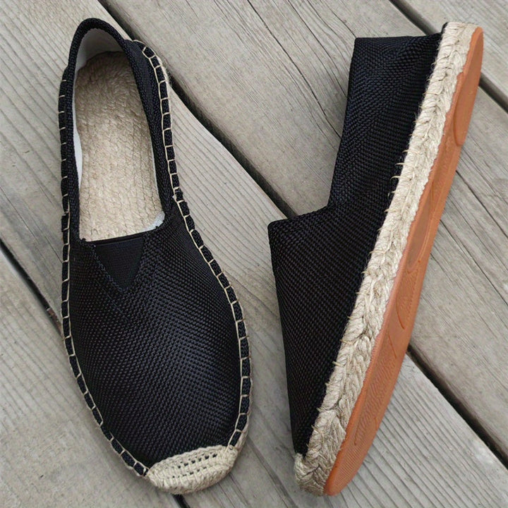 Black espadrille slip-ons with woven jute soles and orange rubber outsole